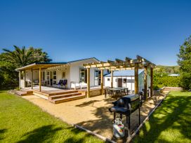 An outdoor area with a deck, table, chairs and barbecue at Pacific Vista - Hawkes Bay