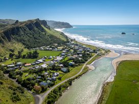 An aerial view of a coastal village near mountains at Pacific Vista - Hawkes Bay Havelock North
