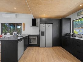 A kitchen with modern appliances at Modern Coastal Tree House - Whangamata Retreat, Whangamata