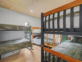 A bedroom with bunk beds and a window at Modern Coastal Tree House - Whangamata Retreat, Whangamata