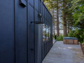 An outdoor area with a shower and hot tub at Modern Coastal Tree House - Whangamata Retreat, Whangamata