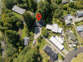 An aerial view of residential properties and road layout at Modern Coastal Tree House - Whangamata Retreat, Whangamata