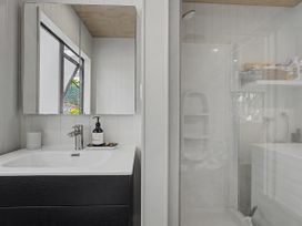 A bathroom with a sink and shower at Modern Coastal Tree House - Whangamata Retreat, Whangamata