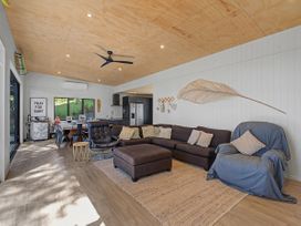 A living room with a sofa and coffee table at Modern Coastal Tree House - Whangamata