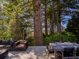 An outdoor seating area with dining table at Modern Coastal Tree House - Whangamata Retreat in Whangamata