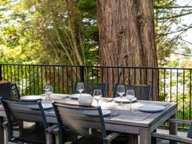 An outdoor dining area with a table and chairs at Modern Coastal Tree House - Whangamata