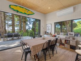 A dining room with a table and chairs at Modern Coastal Tree House - Whangamata Retreat Whangamata