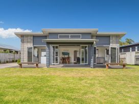 A house with a porch and benches at Sweet As on Aquila - Whitianga Holiday Home Whitianga