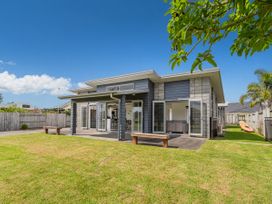 An outdoor view of a house with a yard and benches at Sweet As on Aquila - Whitianga Holiday Home Whitianga