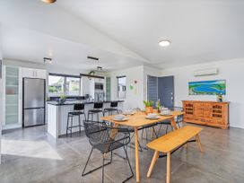 A kitchen with dining table and chairs at Sweet As on Aquila - Whitianga Holiday Home