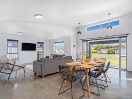 A living room with a dining table and sofa at Sweet As on Aquila - Whitianga Holiday Home
