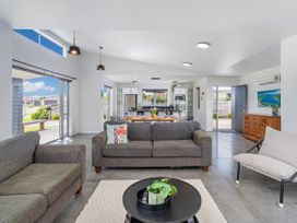 A living room with a sofa and dining area at Sweet As on Aquila - Whitianga Holiday Home Whitianga