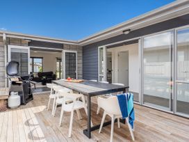 An outdoor dining area with table and chairs at Sweet As on Aquila - Whitianga Holiday Home, Whitianga
