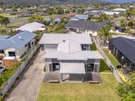 An aerial view of a house with a yard and driveway at Sweet As on Aquila - Whitianga Holiday Home Whitianga