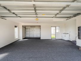 A garage with a garage door and a washing machine at Sweet As on Aquila - Whitianga Holiday Home, Whitianga