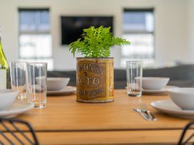 A dining table set with bowls and glasses at Sweet As on Aquila - Whitianga