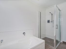 A bathroom with a bathtub and a shower at Sweet As on Aquila - Whitianga Holiday Home