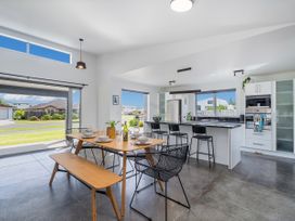 A kitchen with a dining table and chairs at Sweet As on Aquila - Whitianga Holiday Home Whitianga