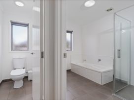 A bathroom with a toilet, bathtub, and shower at Sweet As on Aquila - Whitianga Holiday Home, Whitianga