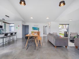 A living room with a sofa and dining table at Sweet As on Aquila - Whitianga Holiday Home Whitianga
