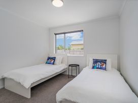 A bedroom with twin beds and a window at Sweet As on Aquila - Whitianga Holiday Home Whitianga