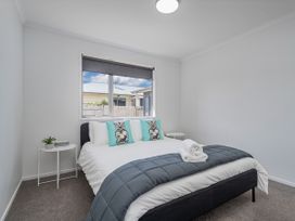 A bedroom with a bed and window at Sweet As on Aquila - Whitianga Holiday Home