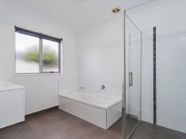 A bathroom with a bath tub and shower at Sweet As on Aquila - Whitianga