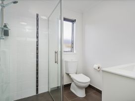 A bathroom with a shower and toilet at Sweet As on Aquila - Whitianga Holiday Home