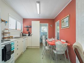 A kitchen with a dining table and chairs at The Schieck Shack - Whitianga