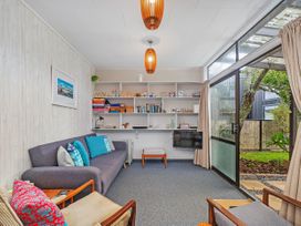 A living room with a sofa and bookshelf at The Schieck Shack - Whitianga