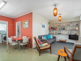 A living room with a table, chairs, and sofa at The Schieck Shack - Whitianga