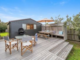 An outdoor deck with seating and a barbecue at The Schieck Shack - Whitianga
