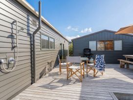 An outdoor area with chairs and a grill at The Schieck Shack - Whitianga