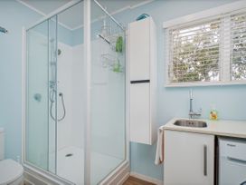 A bathroom with shower, sink and toilet at The Schieck Shack - Whitianga