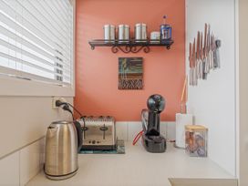 A kitchen countertop with kettle toaster coffee machine and knife rack at The Schieck Shack - Whitianga