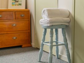 A bedroom with towels on a stool at The Schieck Shack - Whitianga Holiday Home
