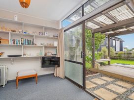 A living room with shelves and a tv at The Schieck Shack - Whitianga