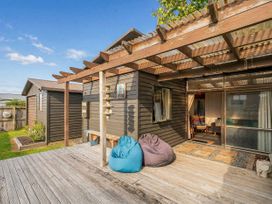 An outdoor area with bean bags and a wooden deck at The Schieck Shack - Whitianga