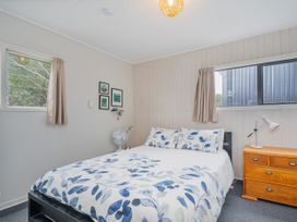 A bedroom with a bed and a dresser at The Schieck Shack - Whitianga