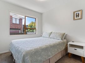 A bedroom featuring a bed with a nightstand and a window at Moana - Onehunga Holiday Home, Auckland