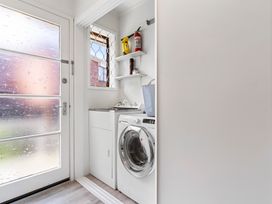 A laundry room with a washing machine and sink at Moana - Onehunga Holiday Home, Auckland