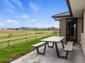 An outdoor area with a table and bench at Riverside Retreat - Waipu