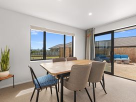 A dining room with a table and chairs at Riverside Retreat - Waipu Holiday Home