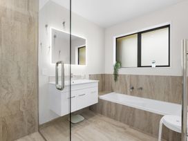 A bathroom with a sink, bathtub, and shower at Riverside Retreat - Waipu