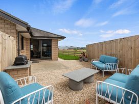An outdoor area with seating and a barbecue grill at Riverside Retreat - Waipu Holiday Home Waipu