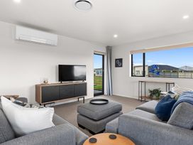 A living room with a sofa and television at Riverside Retreat - Waipu Holiday Home