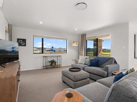 A living room with a television and sofa at Riverside Retreat - Waipu Holiday Home