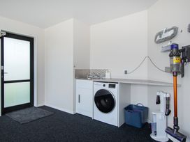 A laundry room with a washing machine and sink at Riverside Retreat - Waipu