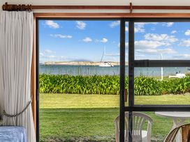View from a window showing water, boats, and greenery at Mangawhai Marvel - Mangawhai Heads