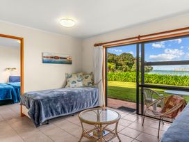 A bedroom with a single bed and a view of the garden at Mangawhai Marvel - Mangawhai Heads